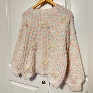 Cozy Cream and Pink Sweater with Bow Accents